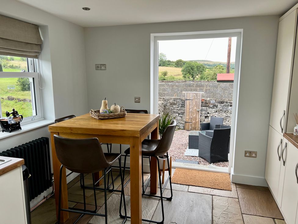 A kitchen with a table and chairs at Penderyn Cottage Aberdare