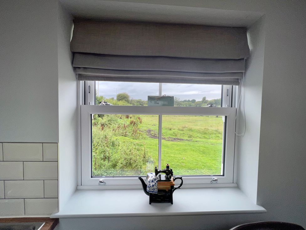 A kitchen window with a teapot on the sill at Penderyn Cottage in Aberdare