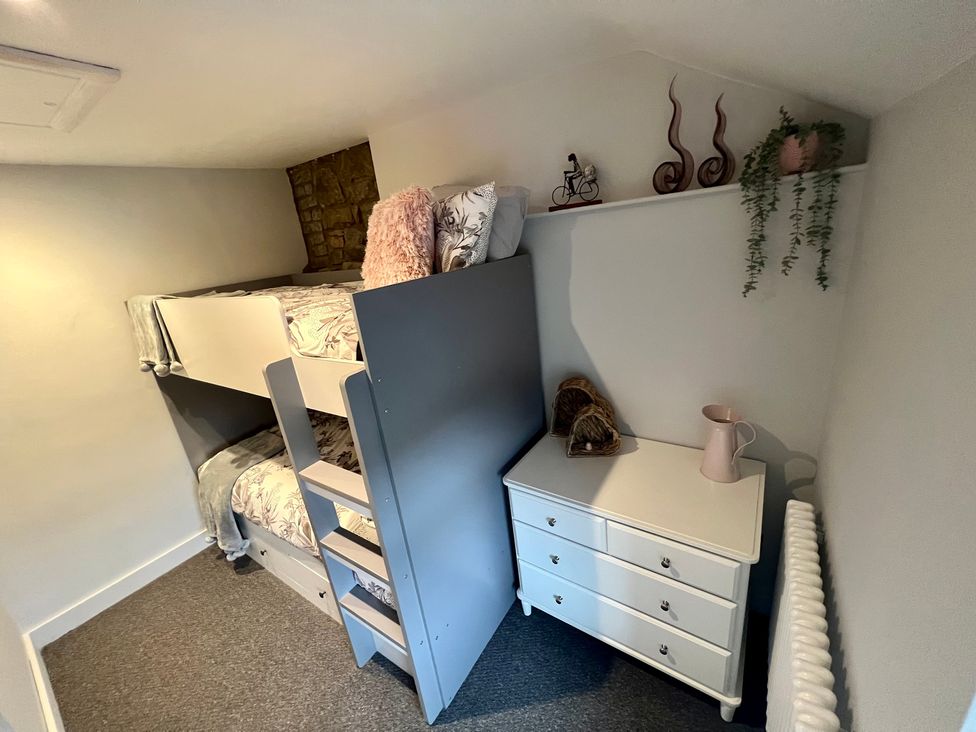 A bedroom with a bunk bed and a dressing table at Penderyn Cottage Aberdare