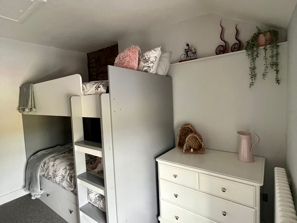 A bedroom with a bunk bed and a dresser at Penderyn Cottage Aberdare