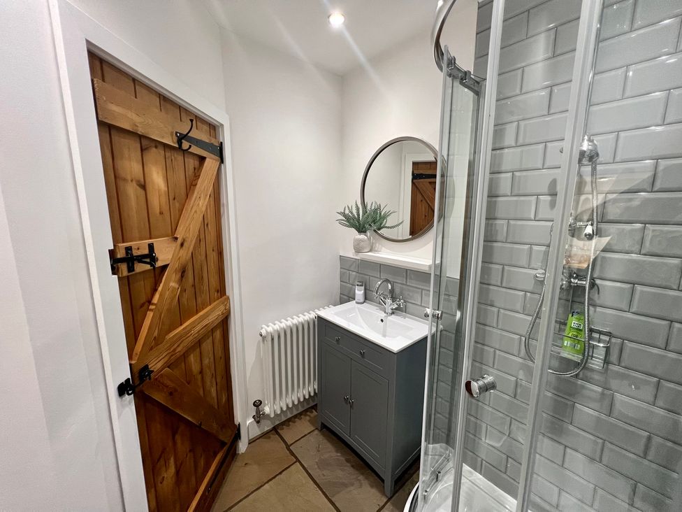 A bathroom with a shower and sink at Penderyn Cottage Aberdare