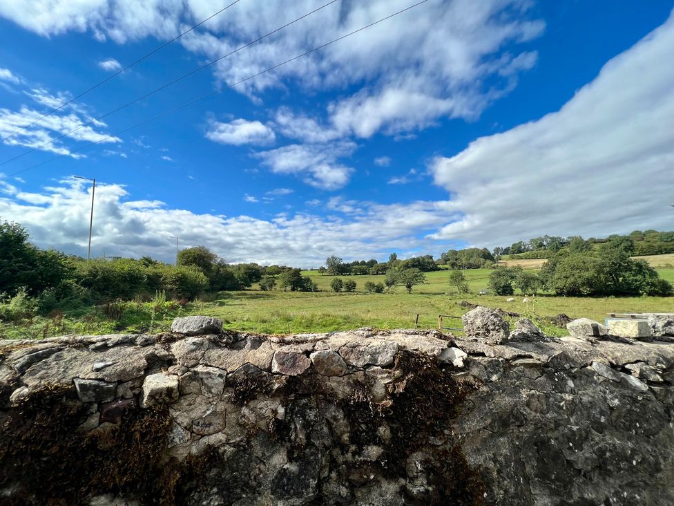 A landscape view with a stone wall and grass at Penderyn Cottage Aberdare