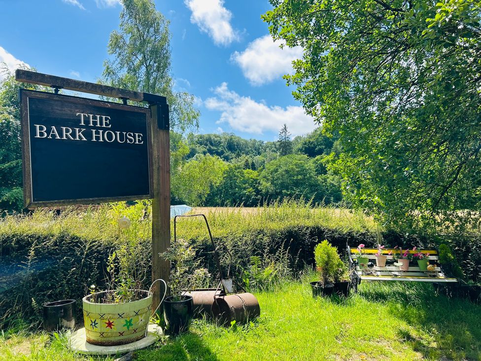A garden with a sign for The Bark House in Tiverton