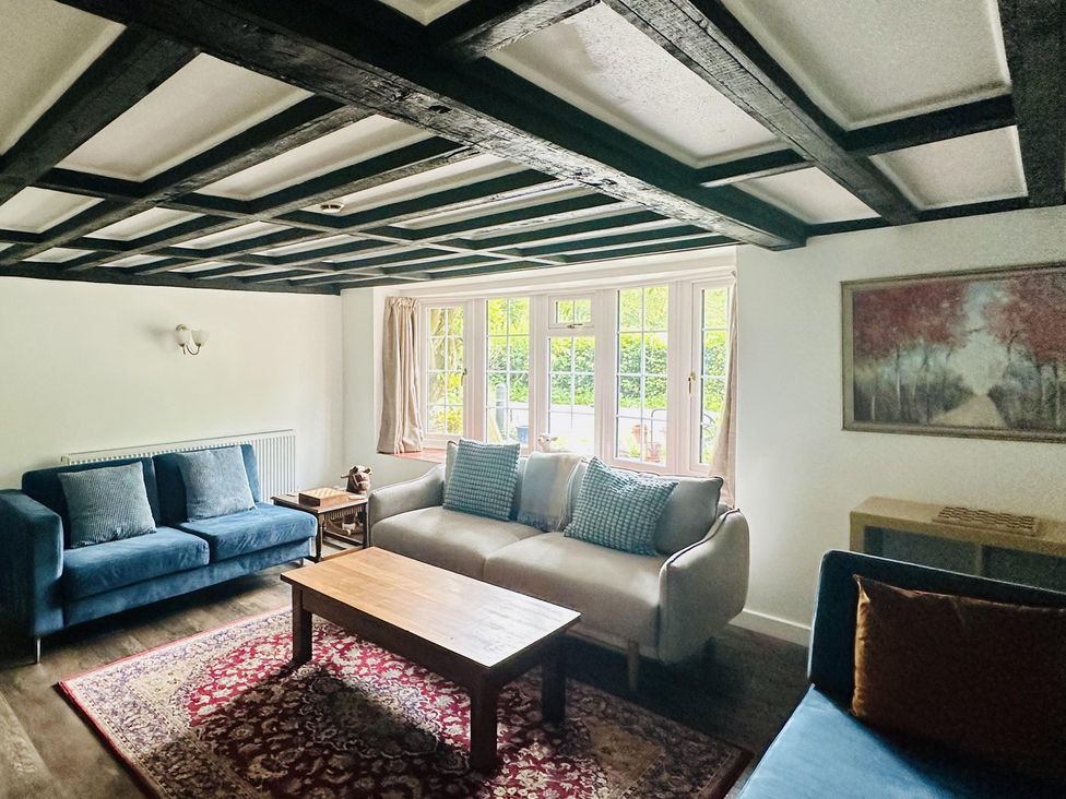 A living room with sofas and a wooden table at The Bark House in Tiverton