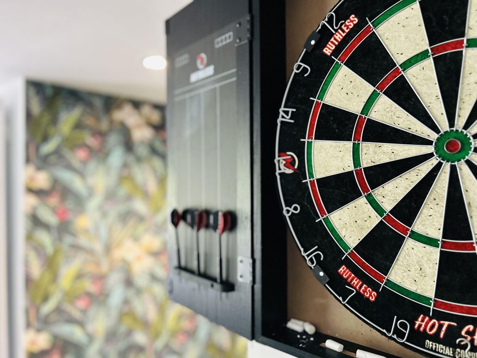 A dartboard and darts with scoreboard at The Bark House in Tiverton