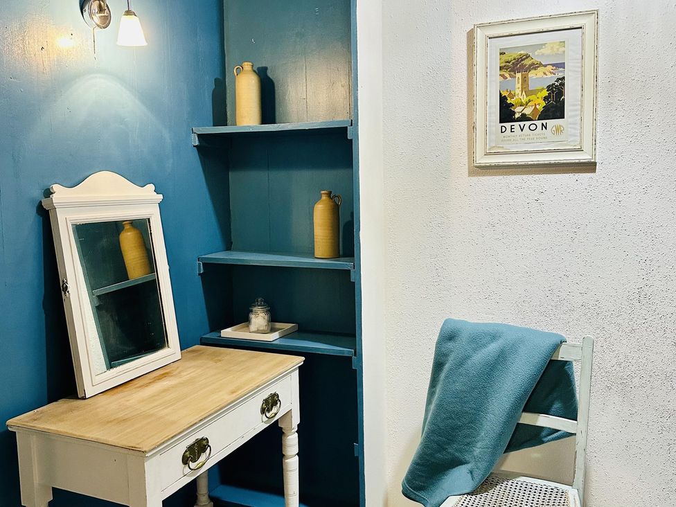 A room with a desk, mirror, shelves, and chair at The Bark House in Tiverton