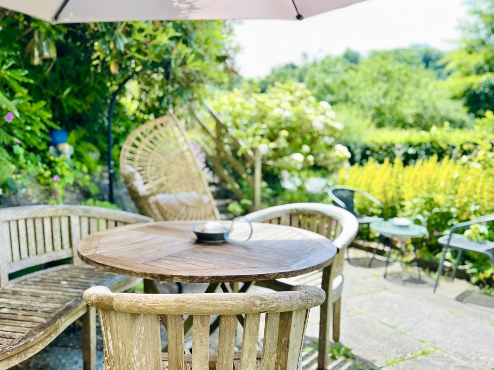 A table and chairs on a patio in the garden at The Bark House Tiverton