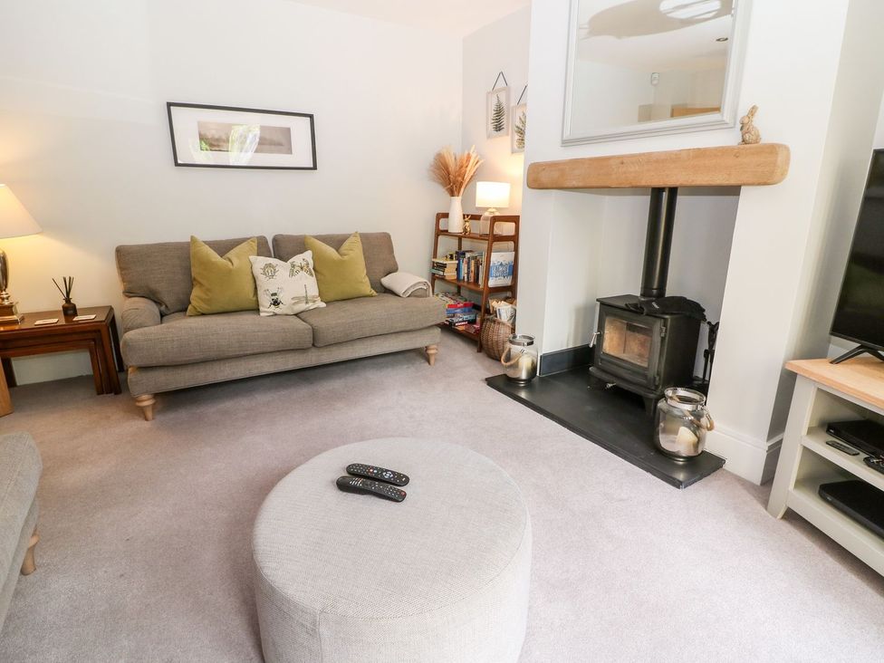 A living room with a sofa and a wood stove at East View in Cheltenham