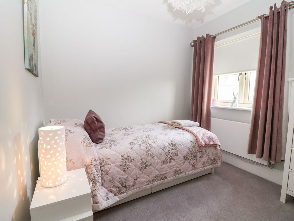 A bedroom with a bed and lamp at East View in Cheltenham