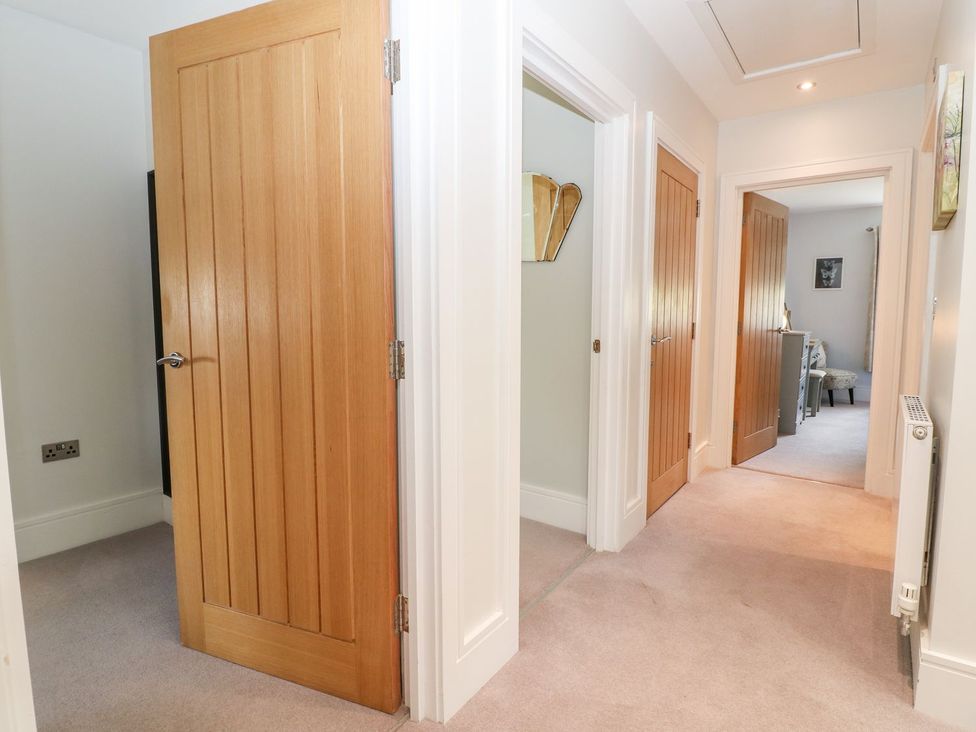 A hallway with multiple doors and a radiator at East View in Cheltenham
