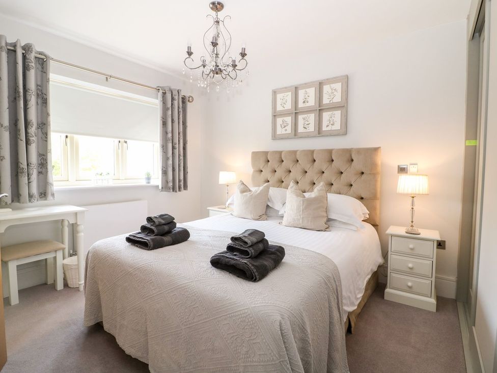 A bedroom with a bed and bedside table at East View in Cheltenham