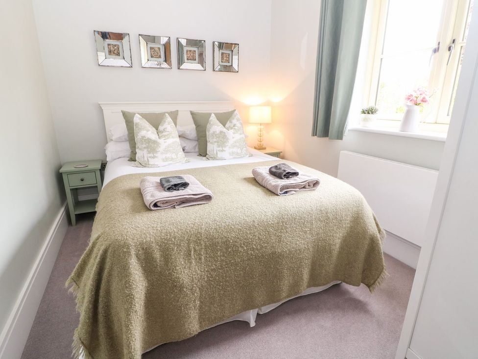 A bedroom with a bed and table at East View in Cheltenham