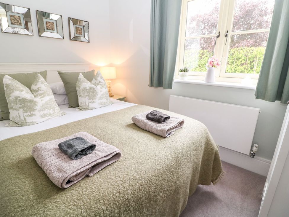 A bedroom with a bed and towels at East View in Cheltenham