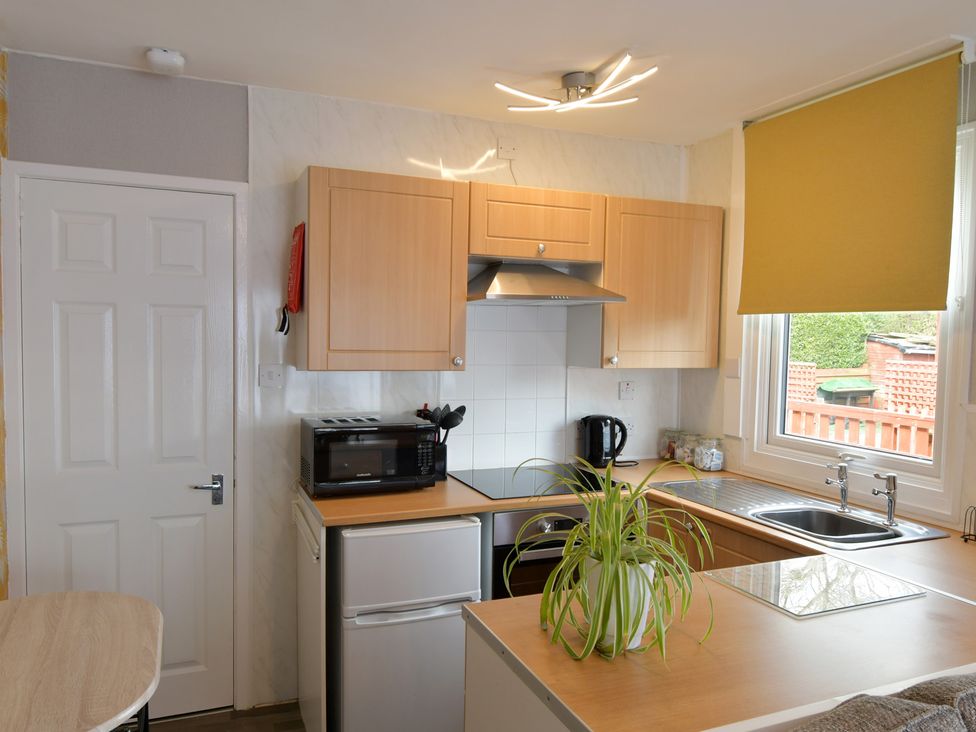 A kitchen with cupboards, stove, sink, and microwave at 228b Eighth Avenue in Bridlington