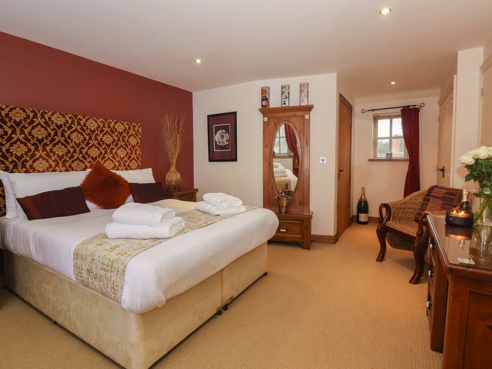 A bedroom with a bed and decorative elements at Champagne Cottage in Malton