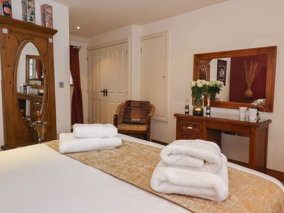 A bedroom with a bed and towels at Champagne Cottage in Malton