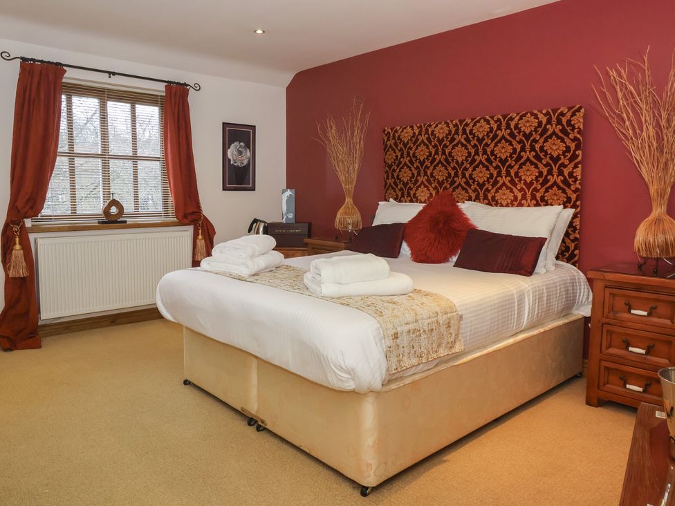A bedroom with a bed and bedside table at Champagne Cottage in Malton