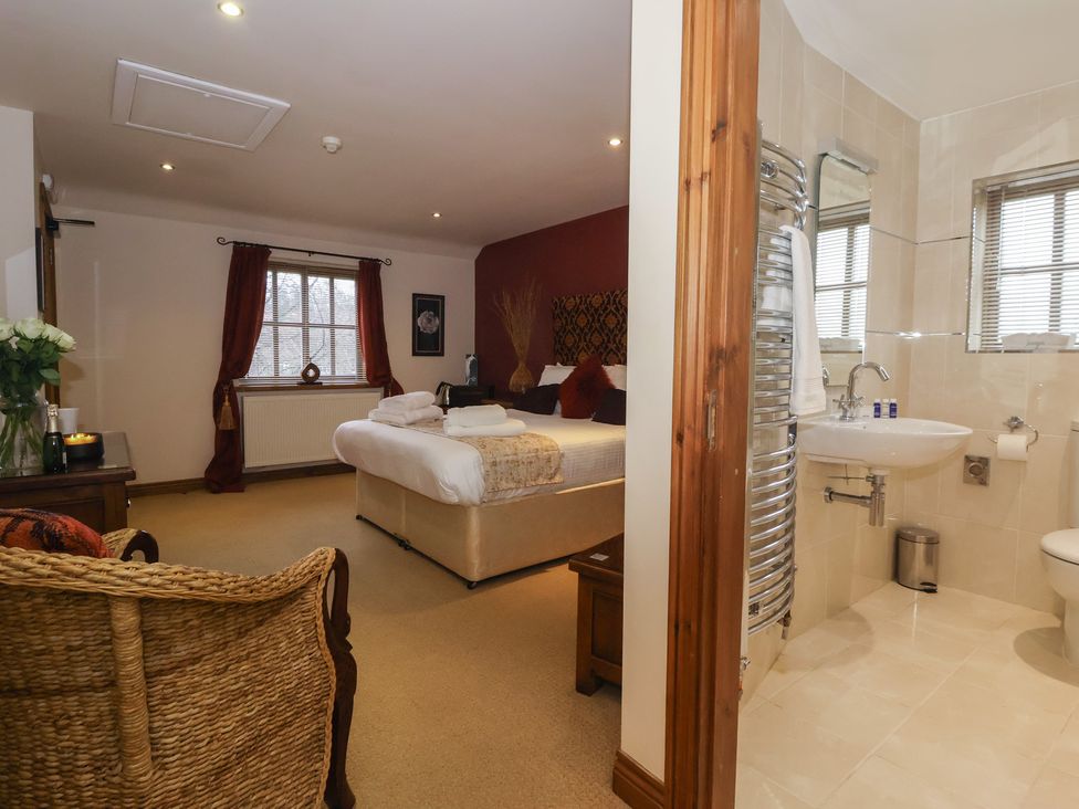 A bedroom with a bed and an adjoining bathroom at Champagne Cottage in Malton