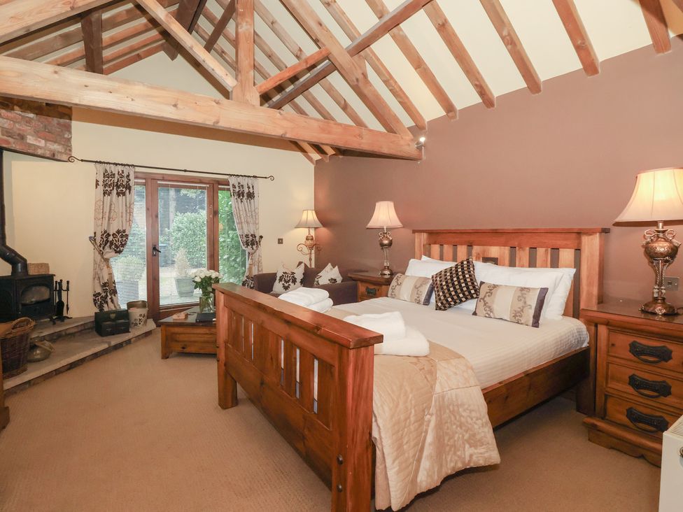 A bedroom with a bed and wooden furniture at Champagne Cottage in Malton