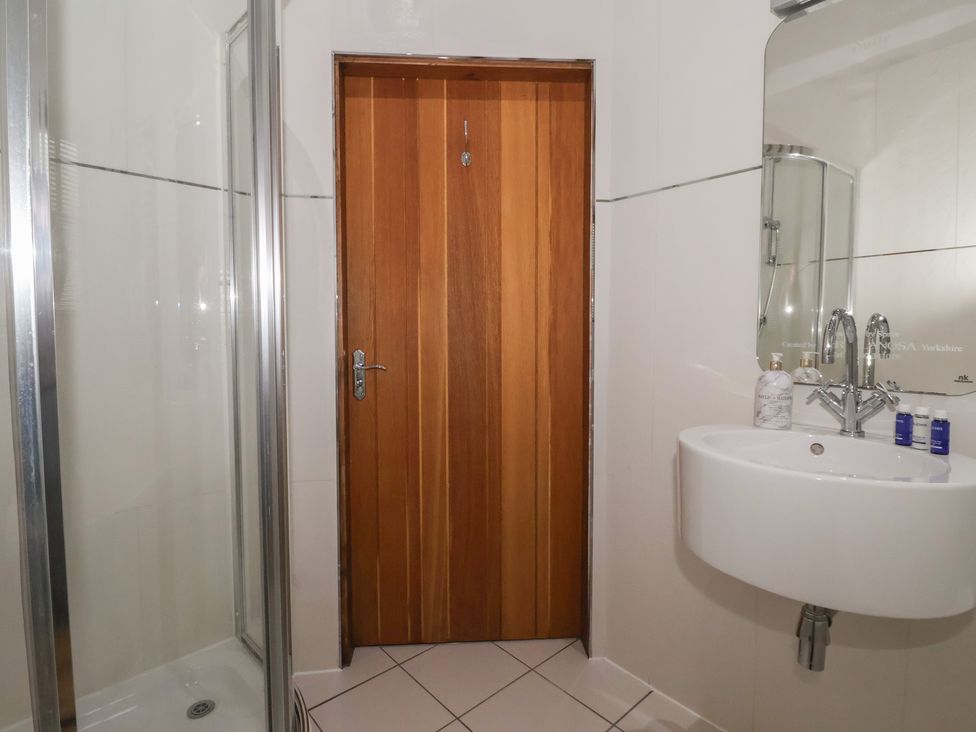 A bathroom with a shower and sink at Champagne Cottage in Malton