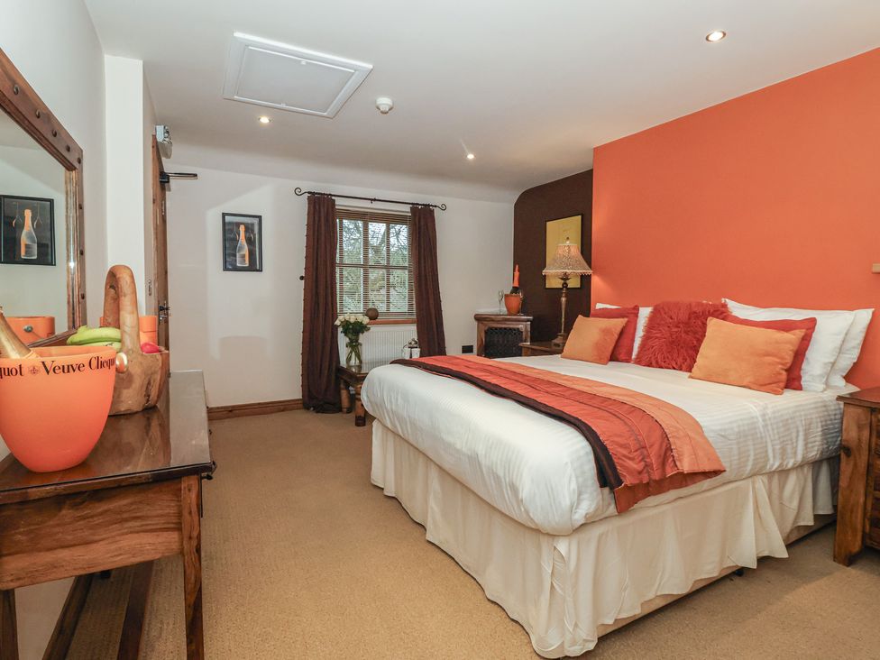 A bedroom with a bed and nightstand at Champagne Cottage in Malton