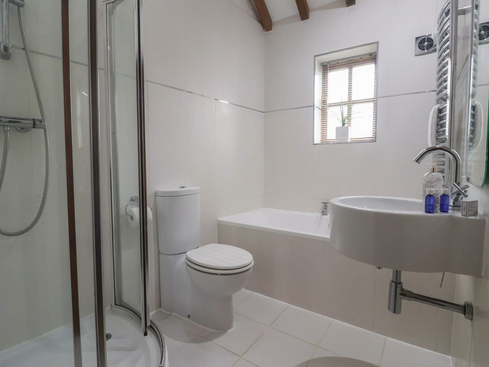 A bathroom with shower, toilet, bathtub, and sink at Champagne Cottage in Malton