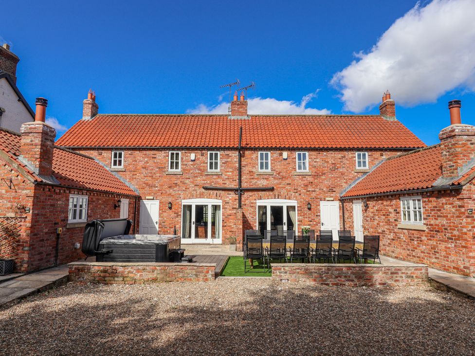 An outdoor area with a brick building and patio at Champagne Cottage in Weaverthorpe