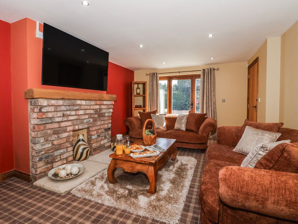 A living room with a fireplace and sofa at Champagne Cottage in Weaverthorpe