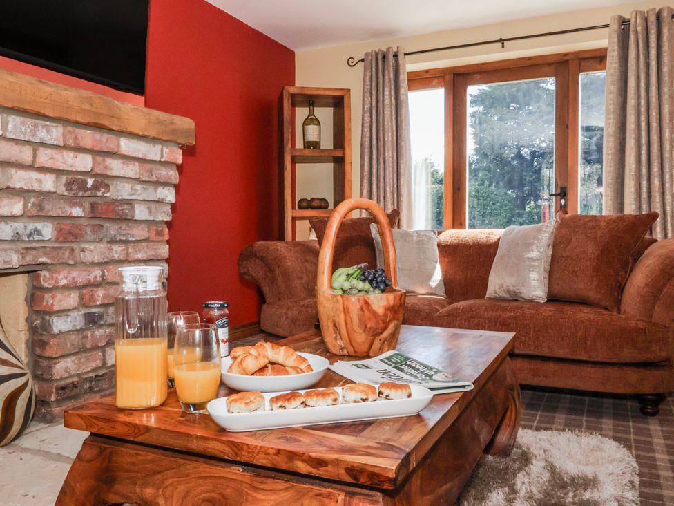 A living room with a couch and a coffee table at Champagne Cottage in Weaverthorpe
