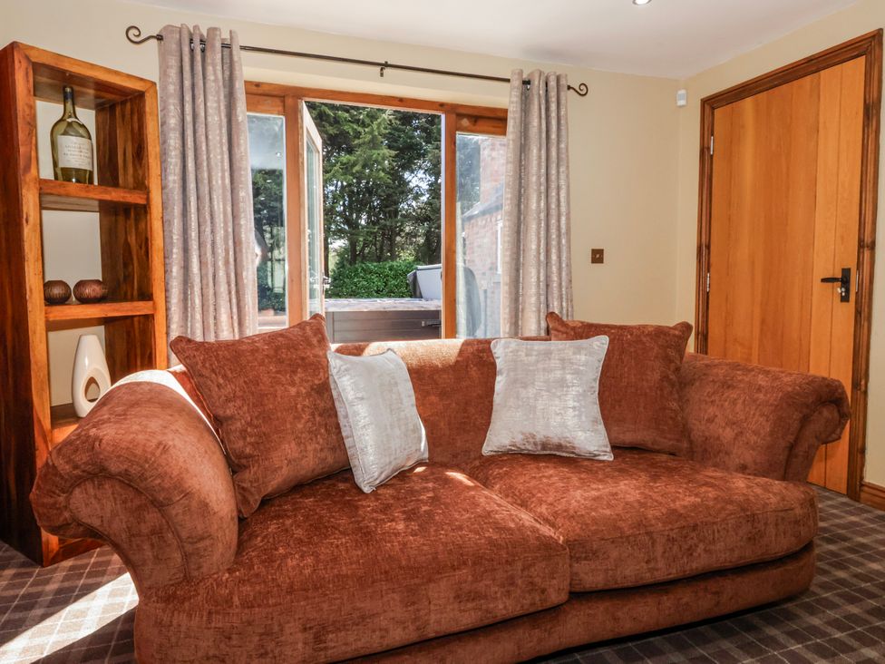 A living room with a sofa and window at Champagne Cottage in Weaverthorpe