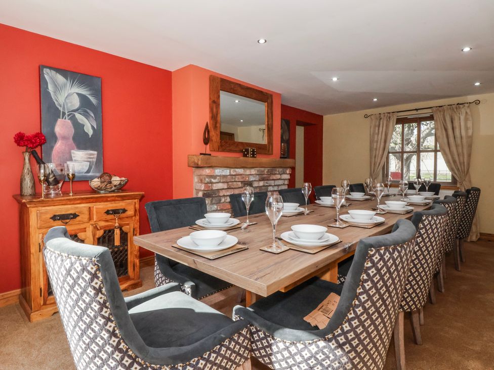 A dining room with a large table set for a meal at Champagne Cottage in Weaverthorpe