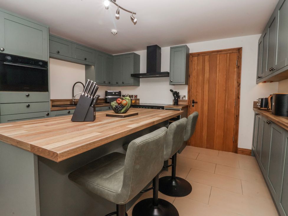 A kitchen with a countertop and stools at Champagne Cottage in Weaverthorpe
