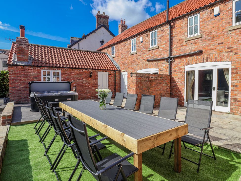 An outdoor dining area with a table and chairs at Champagne Cottage in Weaverthorpe