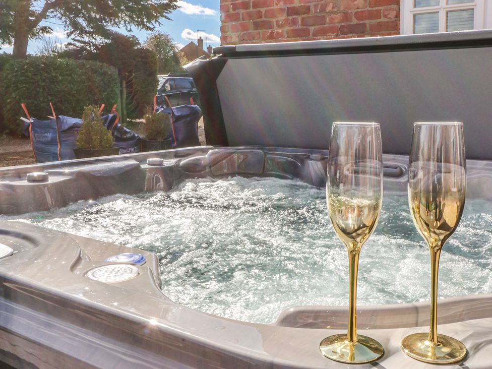 A hot tub with two glasses at Champagne Cottage in Weaverthorpe