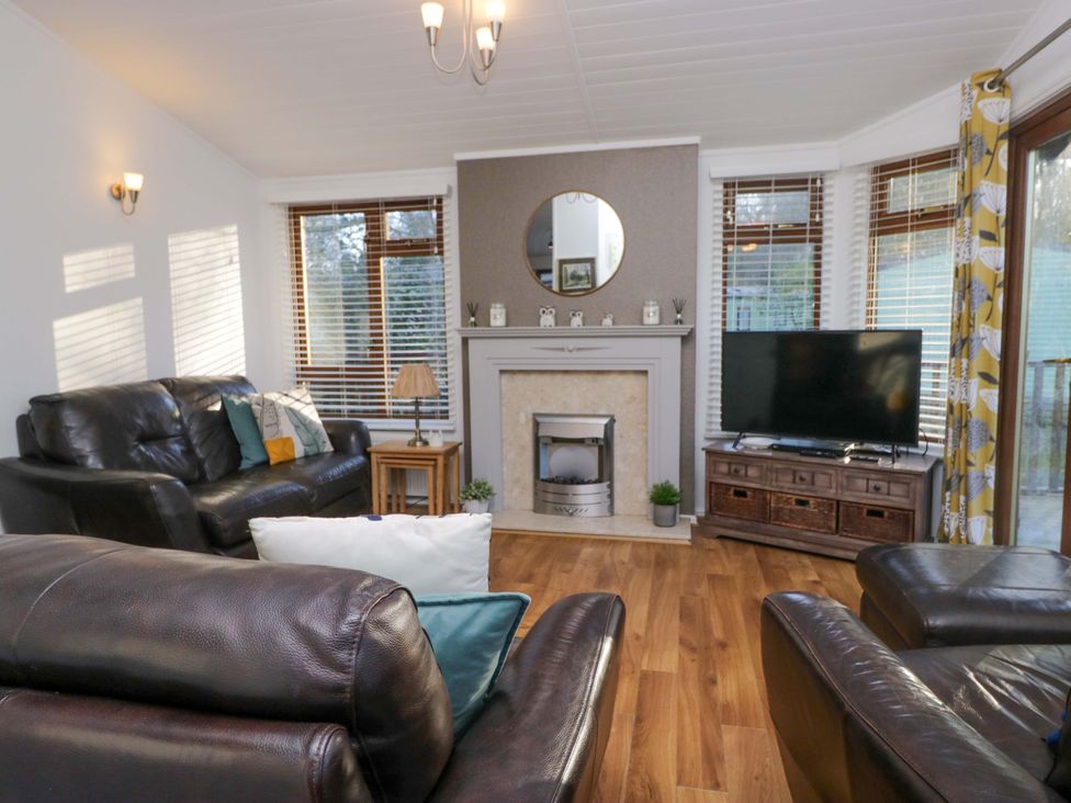 A living room with a sofa and television at 6 Waterside Windermere