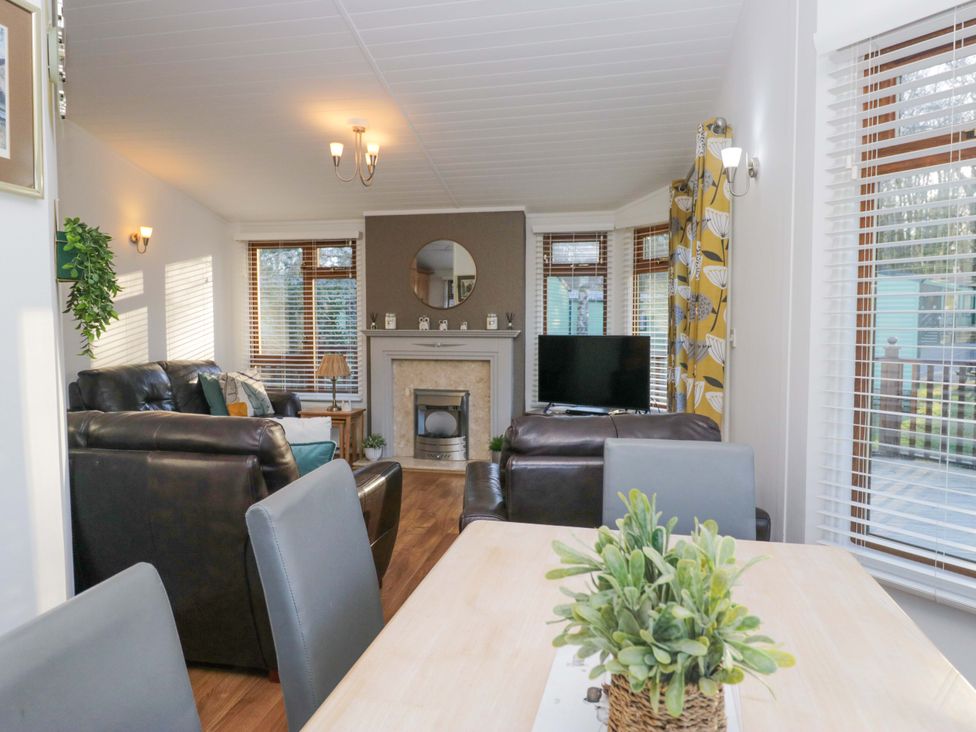 A living room with a sofa and television at 6 Waterside in Windermere