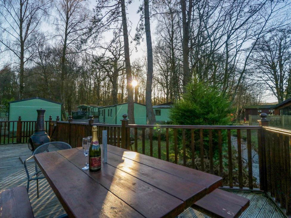 An outdoor setting with a table and wine glasses at 6 Waterside Windermere