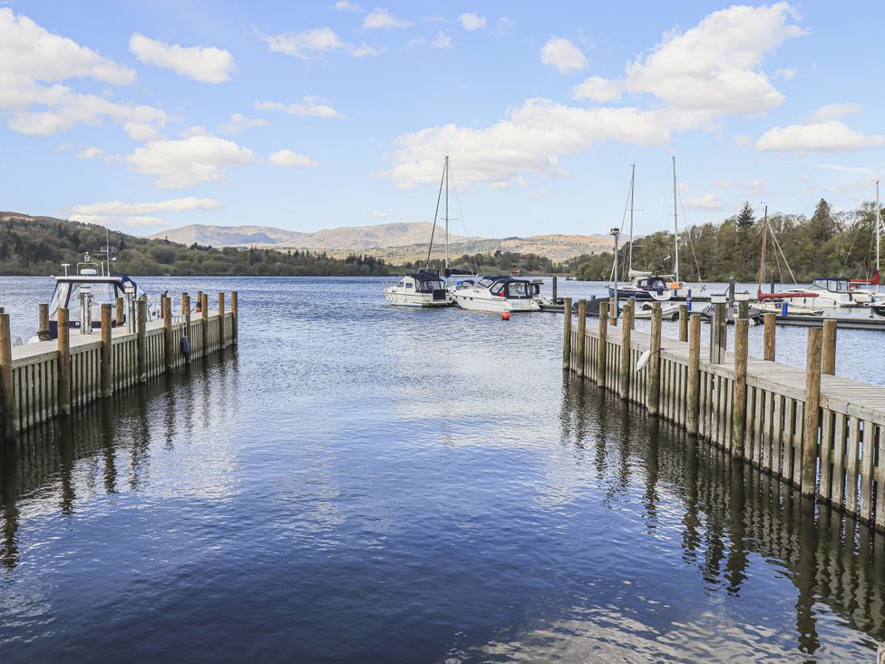A view of boats docked at a pier with mountains in the background at 6 Waterside White Cross Bay Troutbeck Bridge