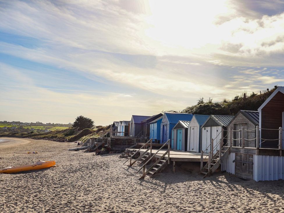 Beach huts along the shoreline at Angorfa Apartment in Abersoch