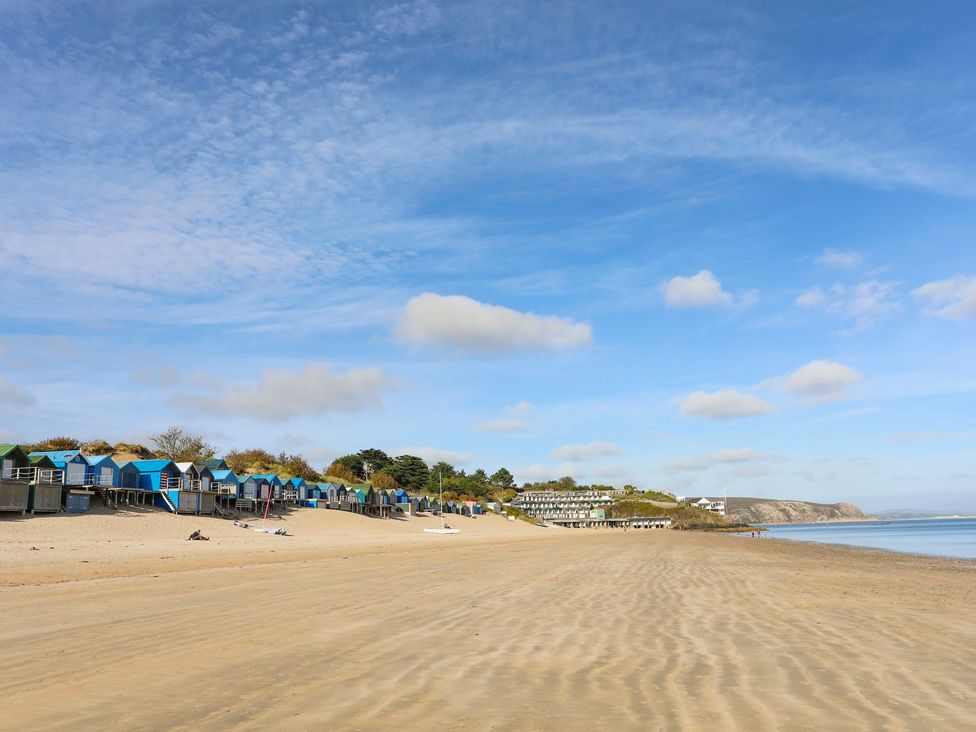A beach with colorful beach huts at Angorfa Apartment in Abersoch