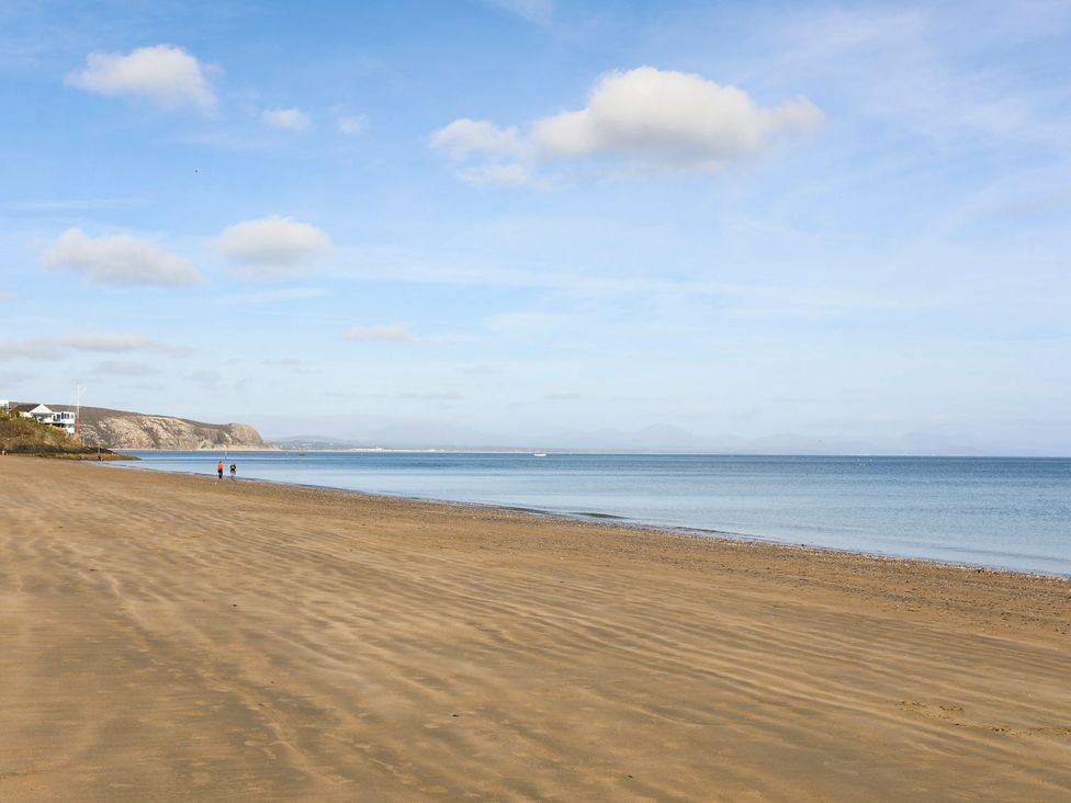 A beach with sand and water at Angorfa Apartment in Abersoch
