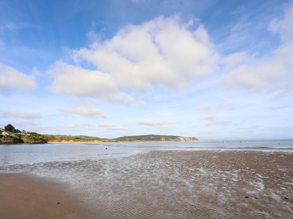A beach scene with water and sand at Angorfa Apartment in Abersoch