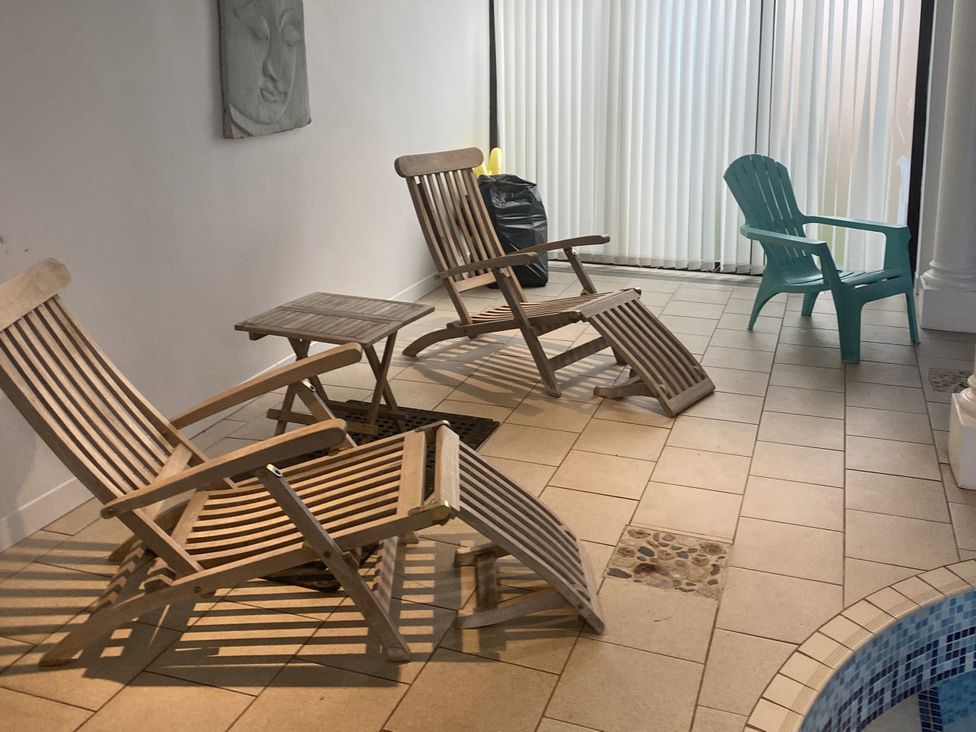 A seating area with chairs and a table at Honeypot Cottage Whitchurch Canonicorum