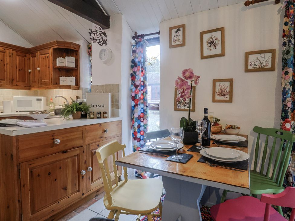 A kitchen with a dining area at Honeypot Cottage Whitchurch Canonicorum
