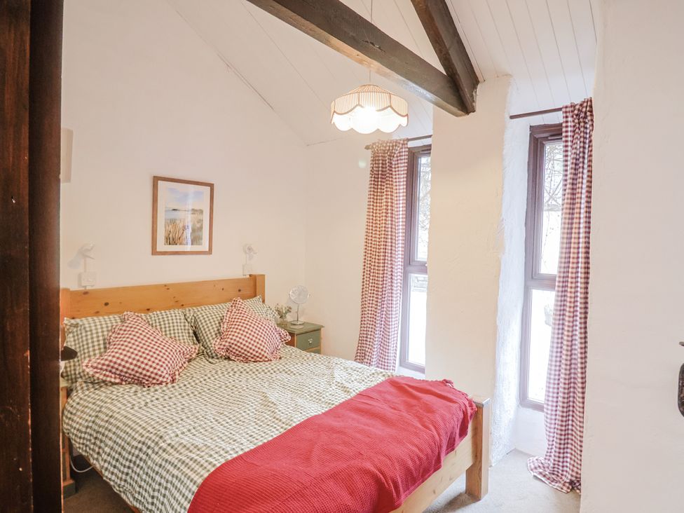 A bedroom with a bed and window at Honeypot Cottage in Whitchurch Canonicorum