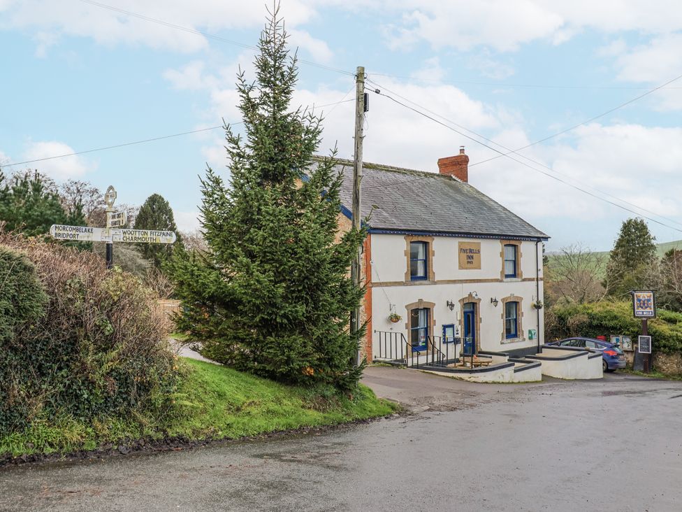 A pub with a signpost at The Five Bells Inn in Whitchurch Canonicorum