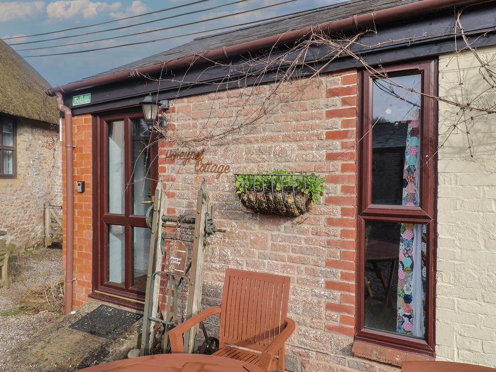 An outdoor view of a cottage with a flower box at Honeypot Cottage Whitchurch Canonicorum