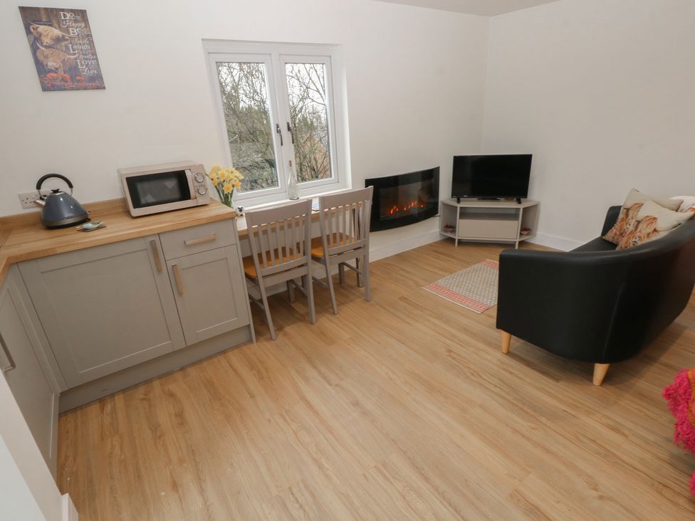 A living room with a kitchenette and a television at Heidiaway Lodge in Porth