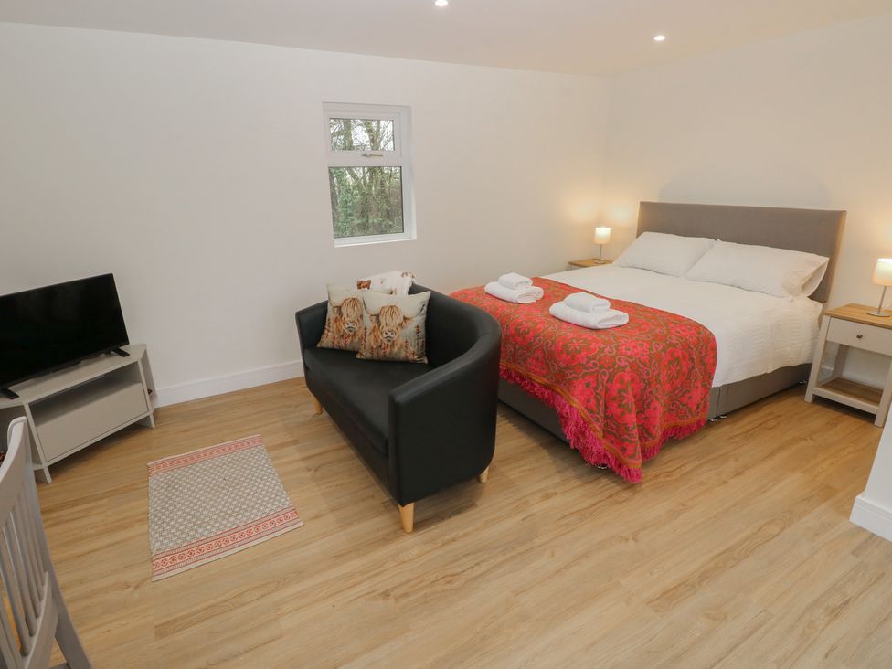 A bedroom with a bed and a sofa at Heidiaway Lodge in Porth