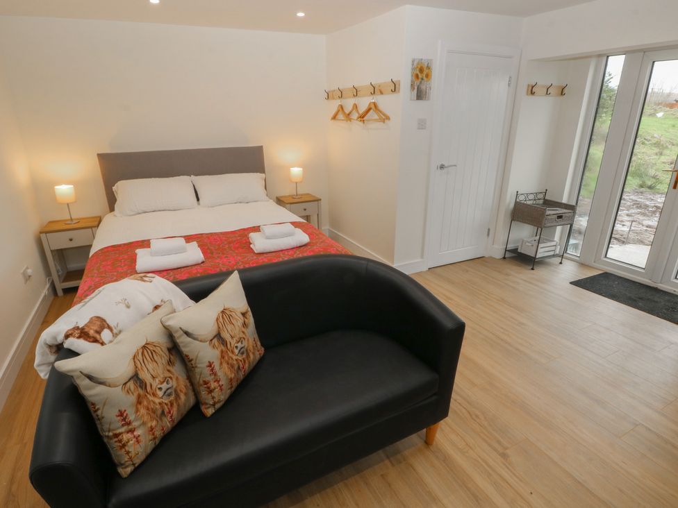 A bedroom with a bed and sofa at Heidiaway Lodge in Porth